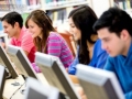 Jovenes estudiando en biblioteca utilizando computadoras